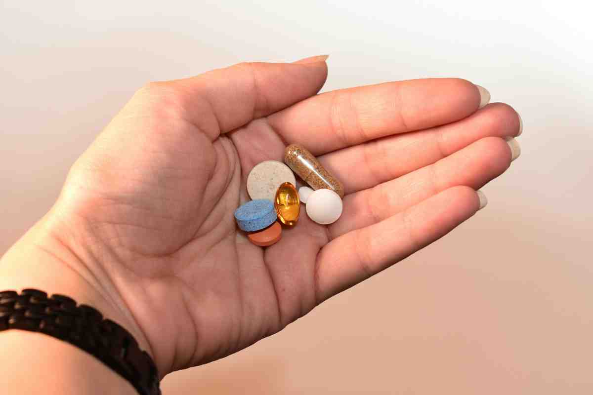 Vitamina B12 si acid folic - combinatia perfecta_Persoana tinand in mana diverse pastile si capsule